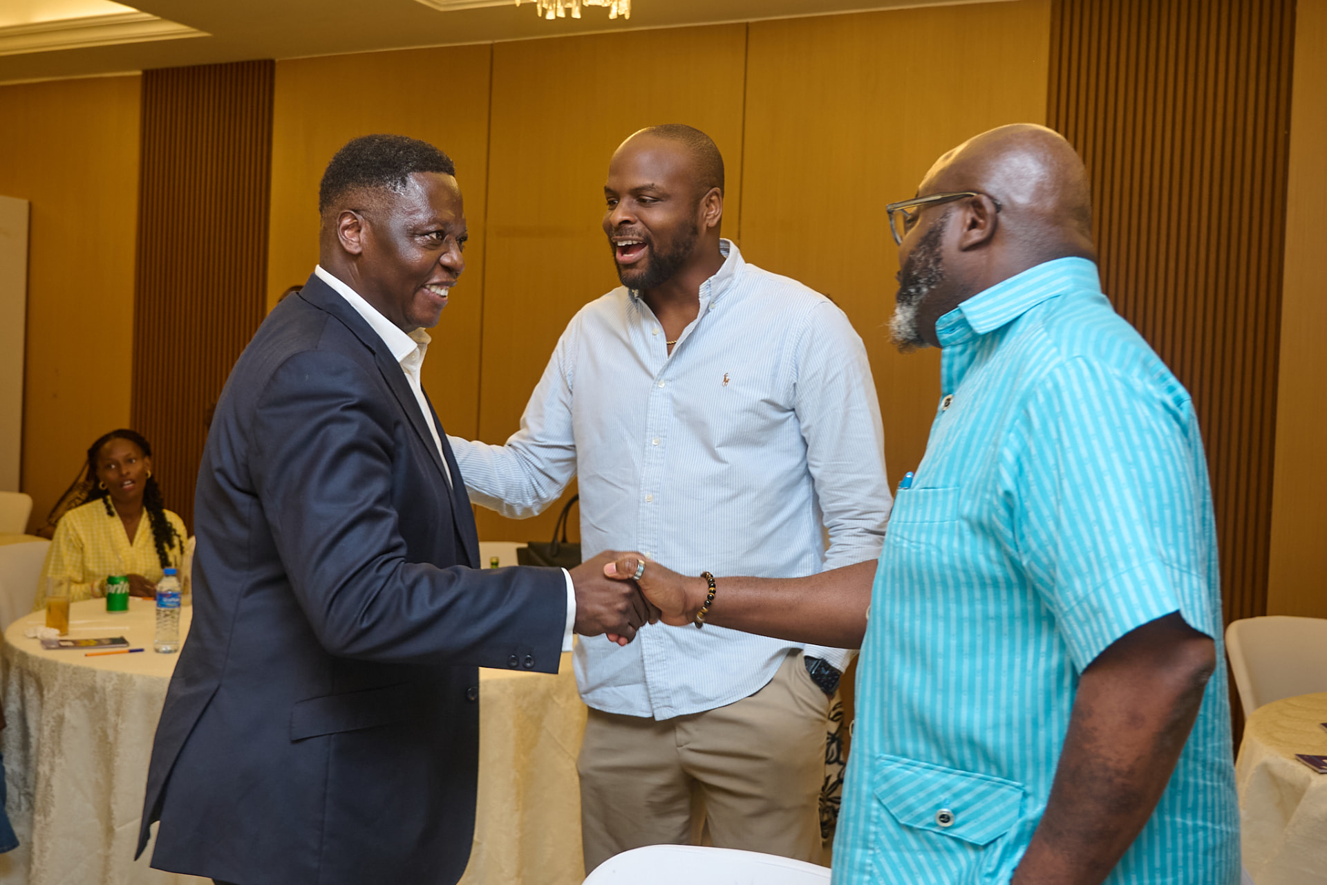 Three guests greeting one another at the Salone Angel Network launch in Freetown